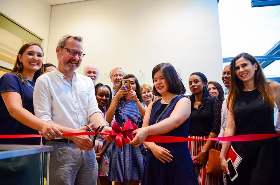 Picture of our Students and Michael Krennerich cutting the ribbon to open their exhibition "Starting Over!"