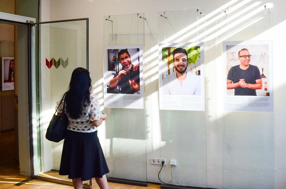 Picture of a guest at the exhibition "Starting Over!" reading one of the portraits