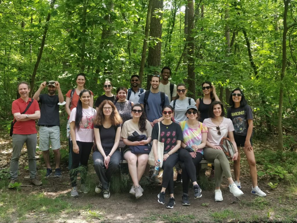 group of students and teachers standing in front of trees during a hike