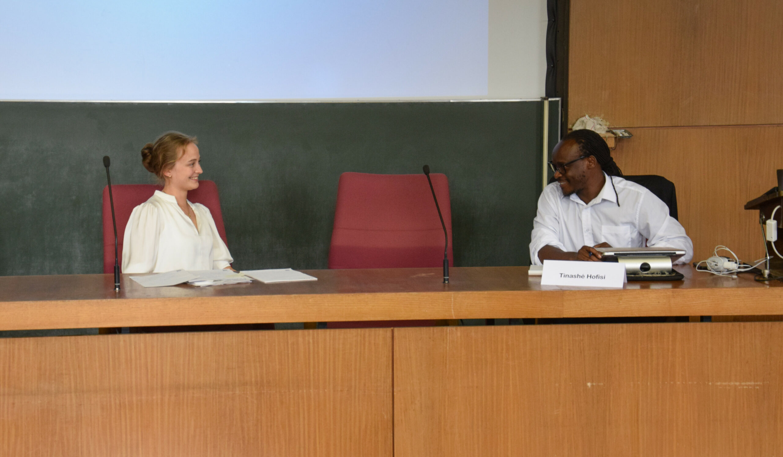Picture of Tinashé Hofisi and moderator Katharina König during lecture.