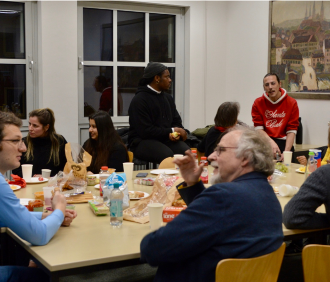 People talking, sitting around a table with snacks