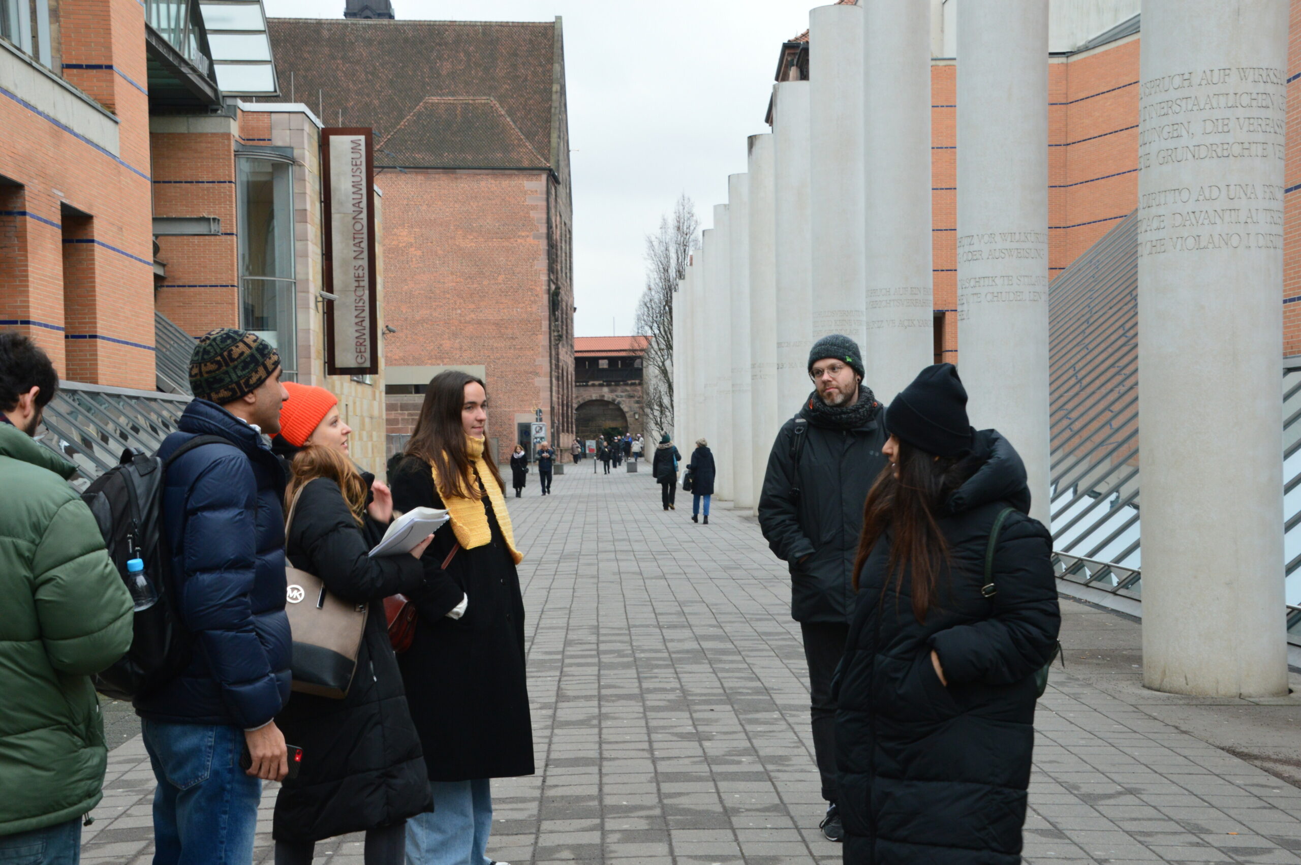 Tour guide and MA Human Rights student discussing the articles engraved into the collar on the "Way of Human Rights"